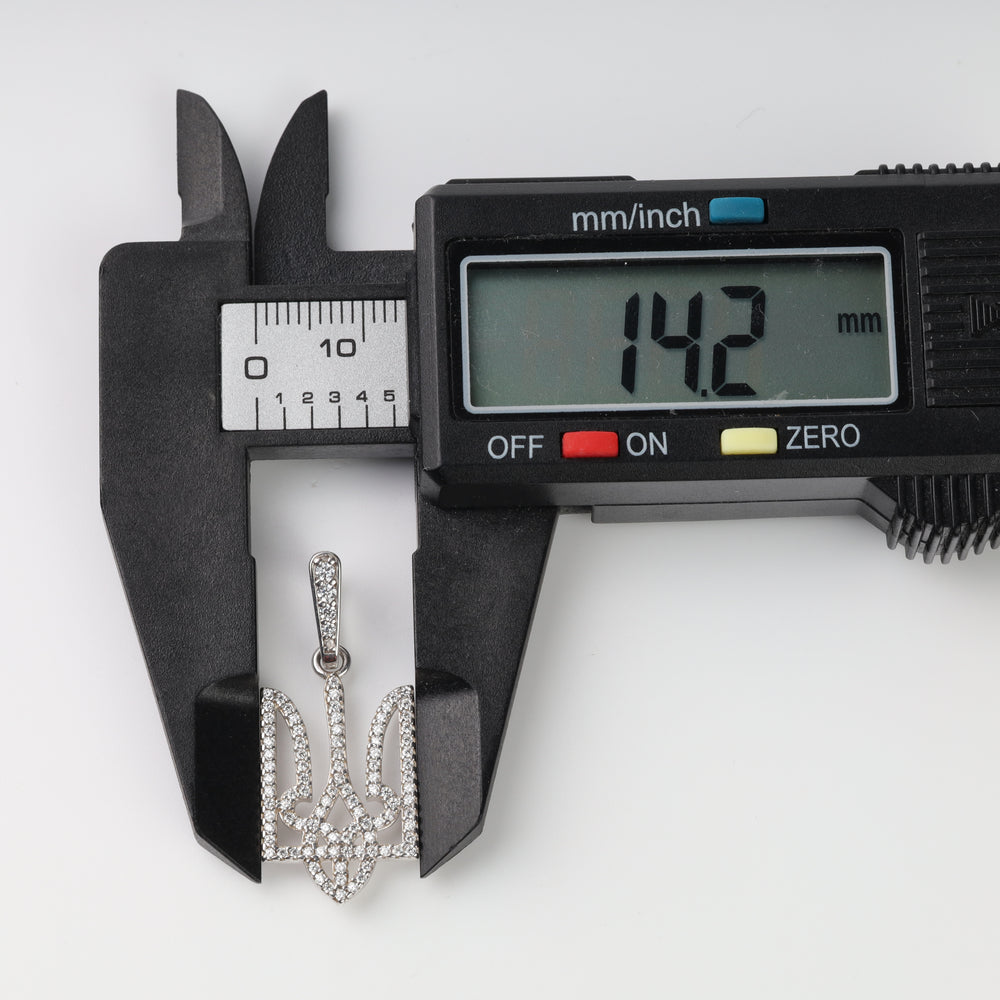 Caliper measuring the pavé clear stone Tryzub pendant width at 14.2 mm