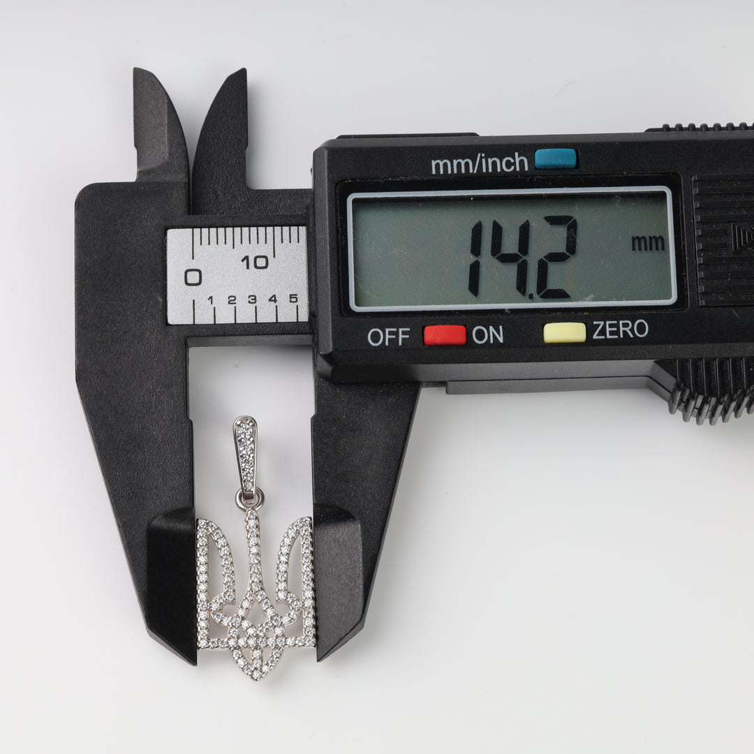 Caliper measuring the pavé clear stone Tryzub pendant width at 14.2 mm