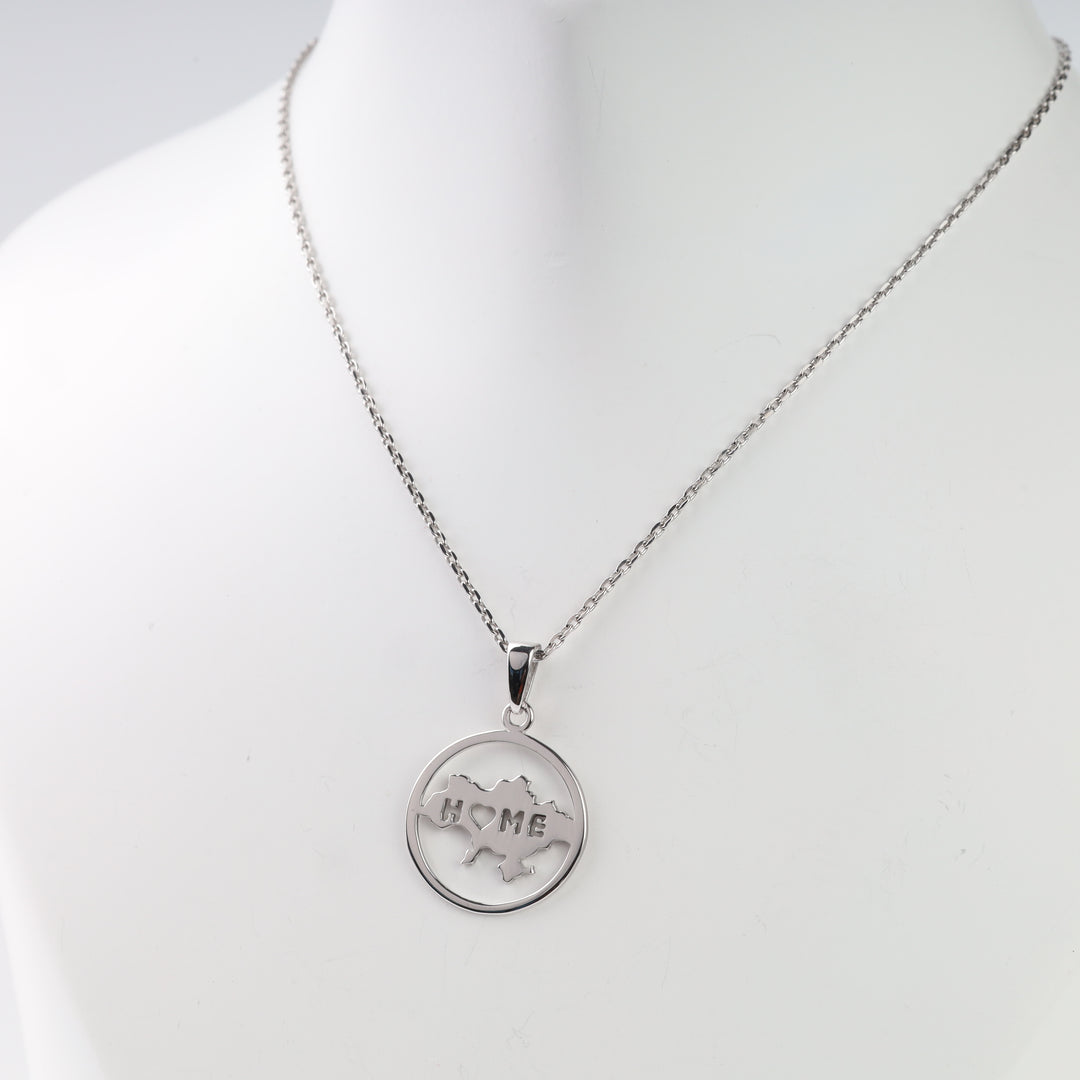 Close view of the round Ukraine map pendant with HOME lettering and a heart-shaped letter O