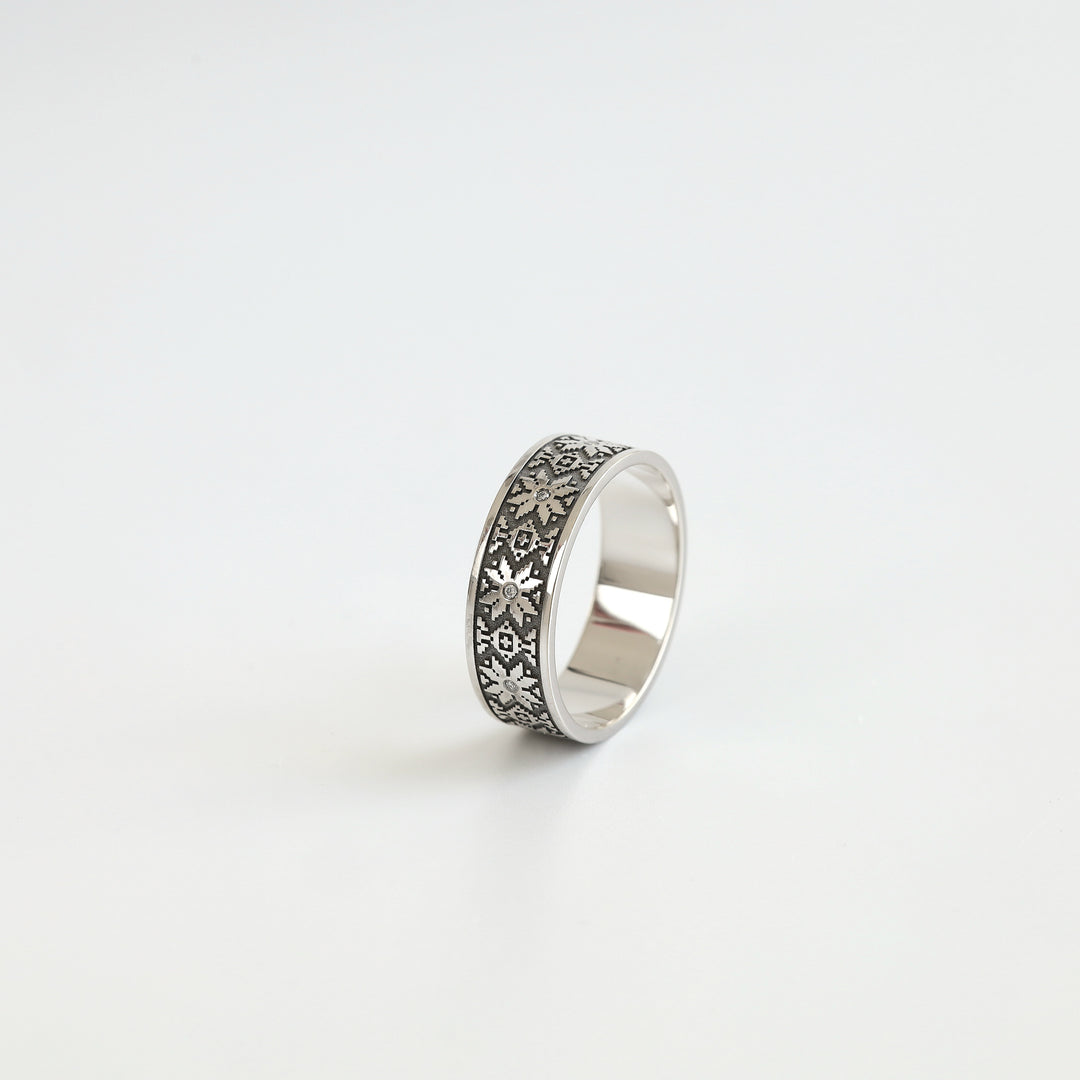 Ukrainian vyshyvanka wedding band in 14K white gold with white diamond accents, angled view