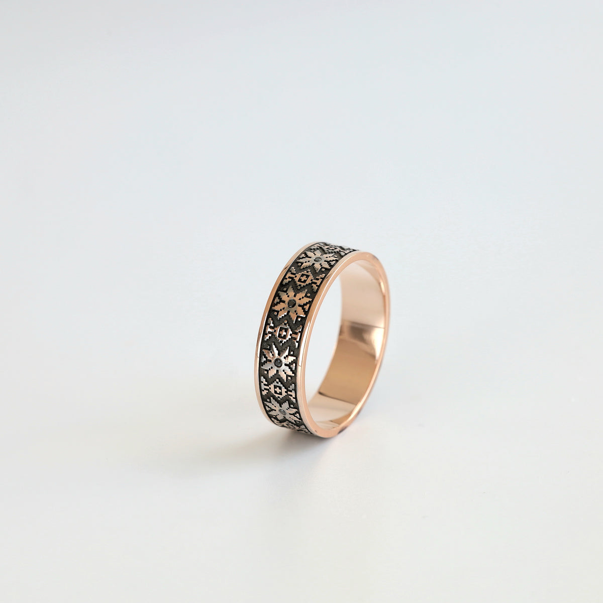Ukrainian vyshyvanka wedding band in 14K rose gold with black diamond accents, angled view