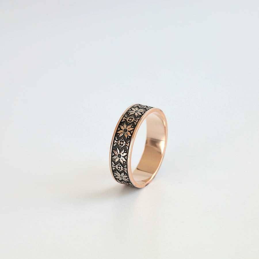 Ukrainian vyshyvanka wedding band in 14K rose gold with black diamond accents, angled view
