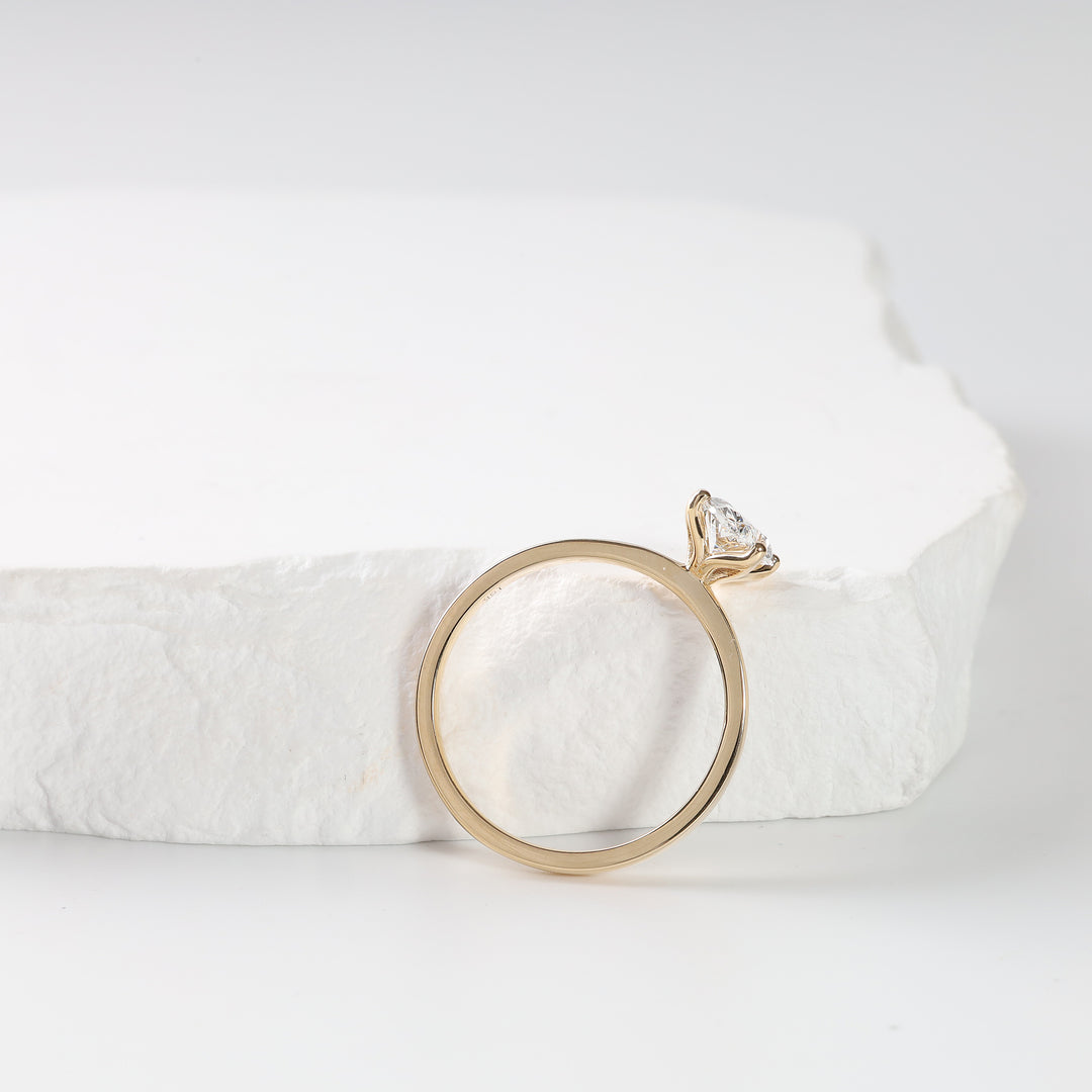 18K yellow gold oval lab-grown diamond solitaire ring standing upright, side profile showing the slim band.