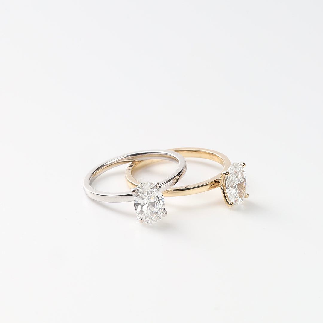 Yellow gold and white gold oval lab-grown diamond solitaire rings shown together on a white background.