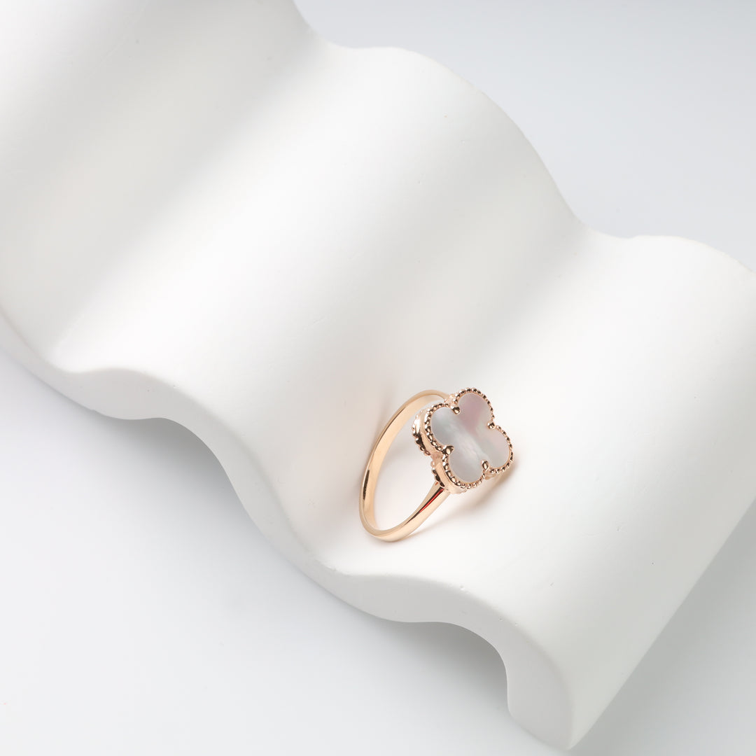 Mother-of-pearl clover ring in rose gold photographed at an angle