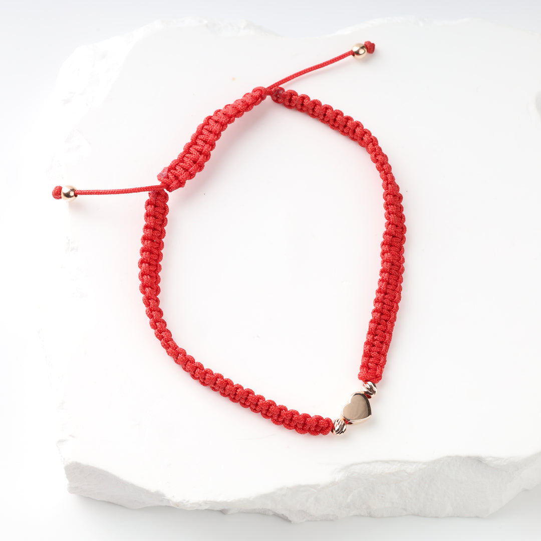 Full view of adjustable red cord heart bracelet with sliding closure