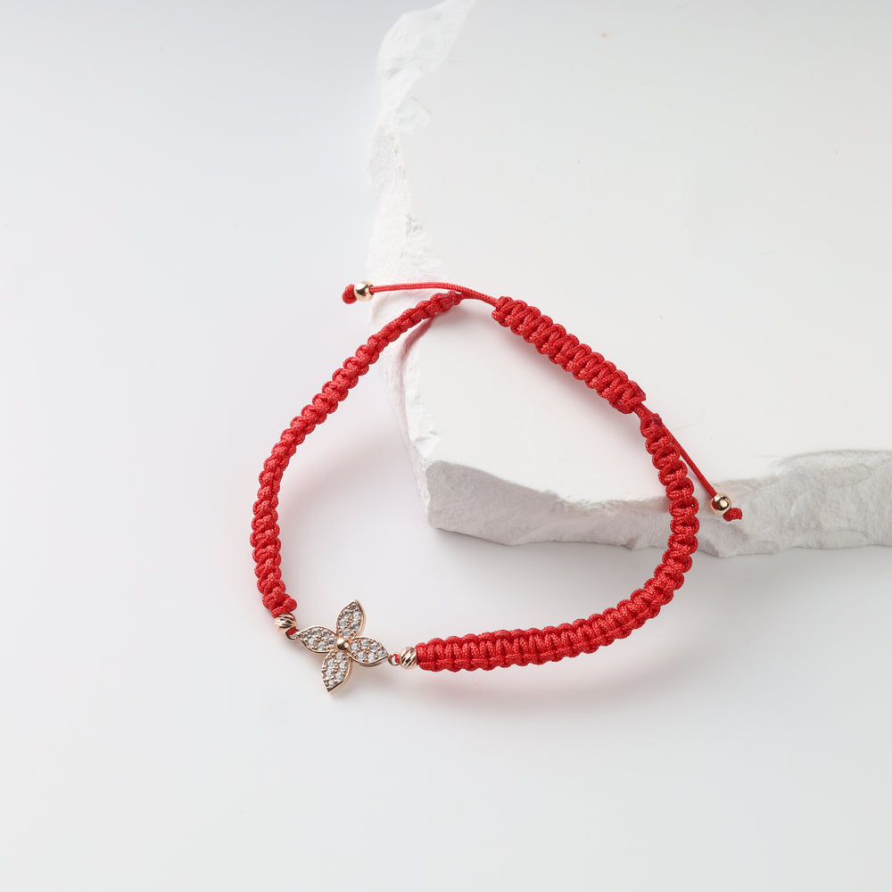 Rose gold floral centerpiece and faceted beads on an adjustable red cord bracelet
