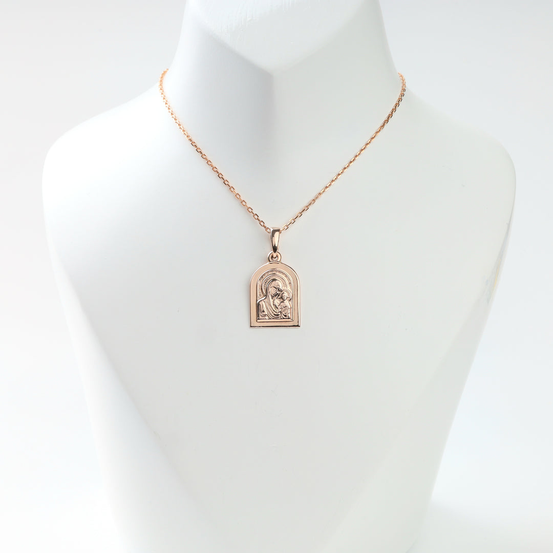 Rose gold Madonna and Child pendant displayed on a necklace bust