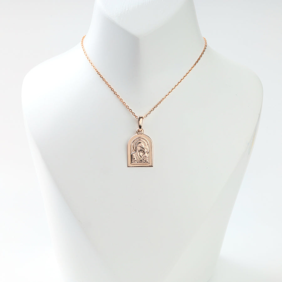 Rose gold Madonna and Child pendant displayed on a necklace bust