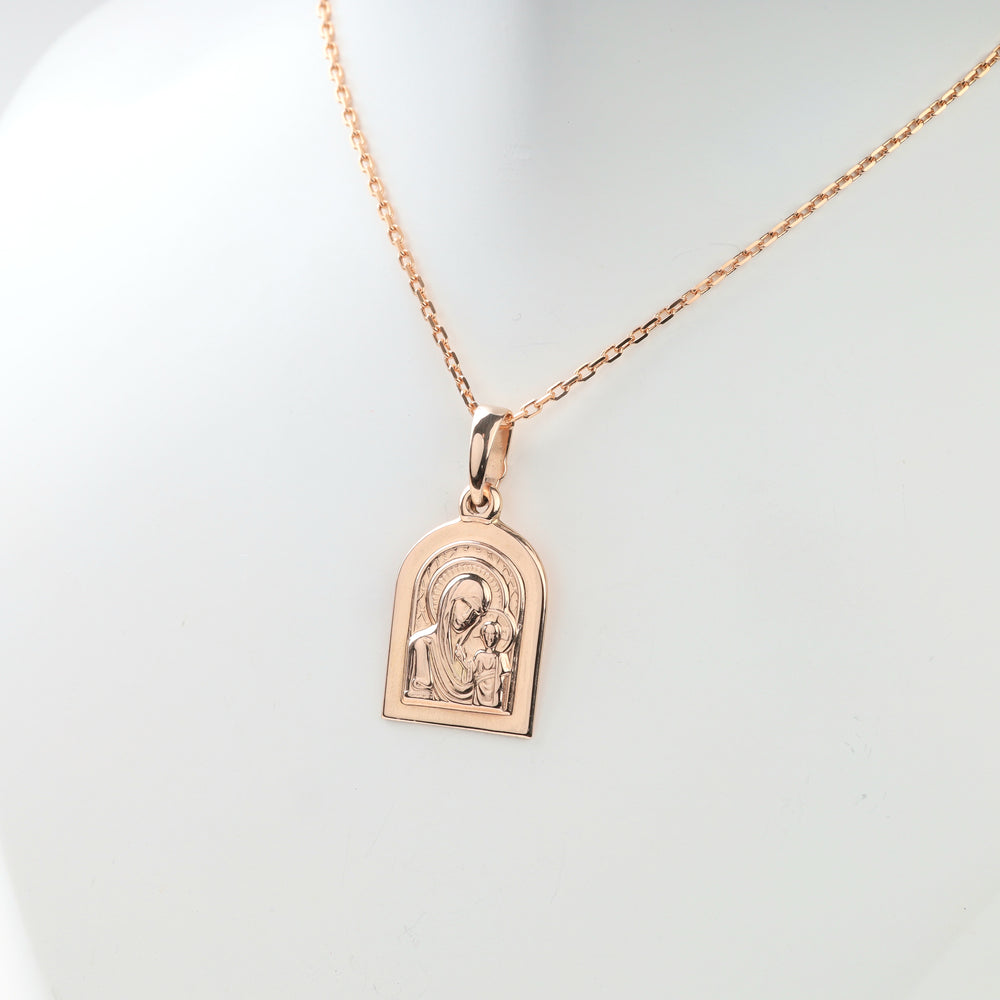 Close view of raised details on Virgin Mary and Child gold pendant