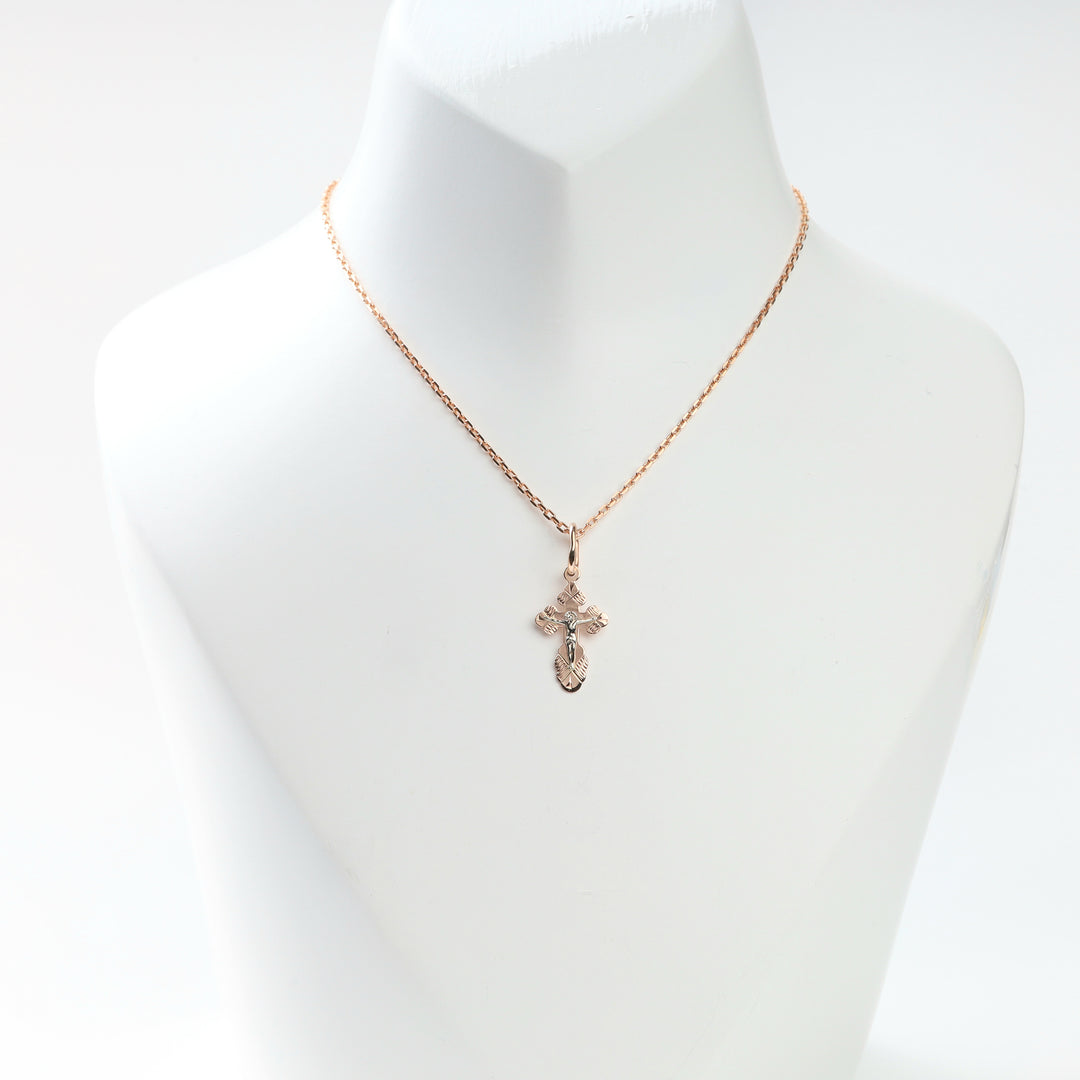 Two-tone gold crucifix cross pendant displayed on a fine rose gold chain