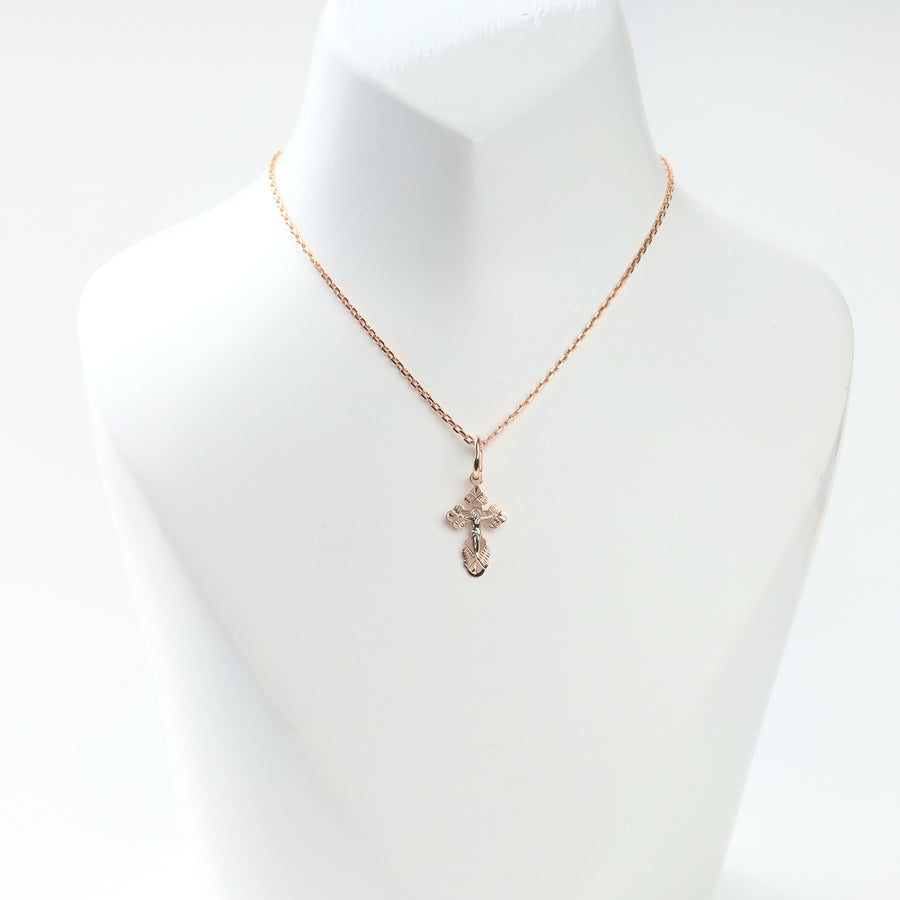 Two-tone gold crucifix cross pendant displayed on a fine rose gold chain