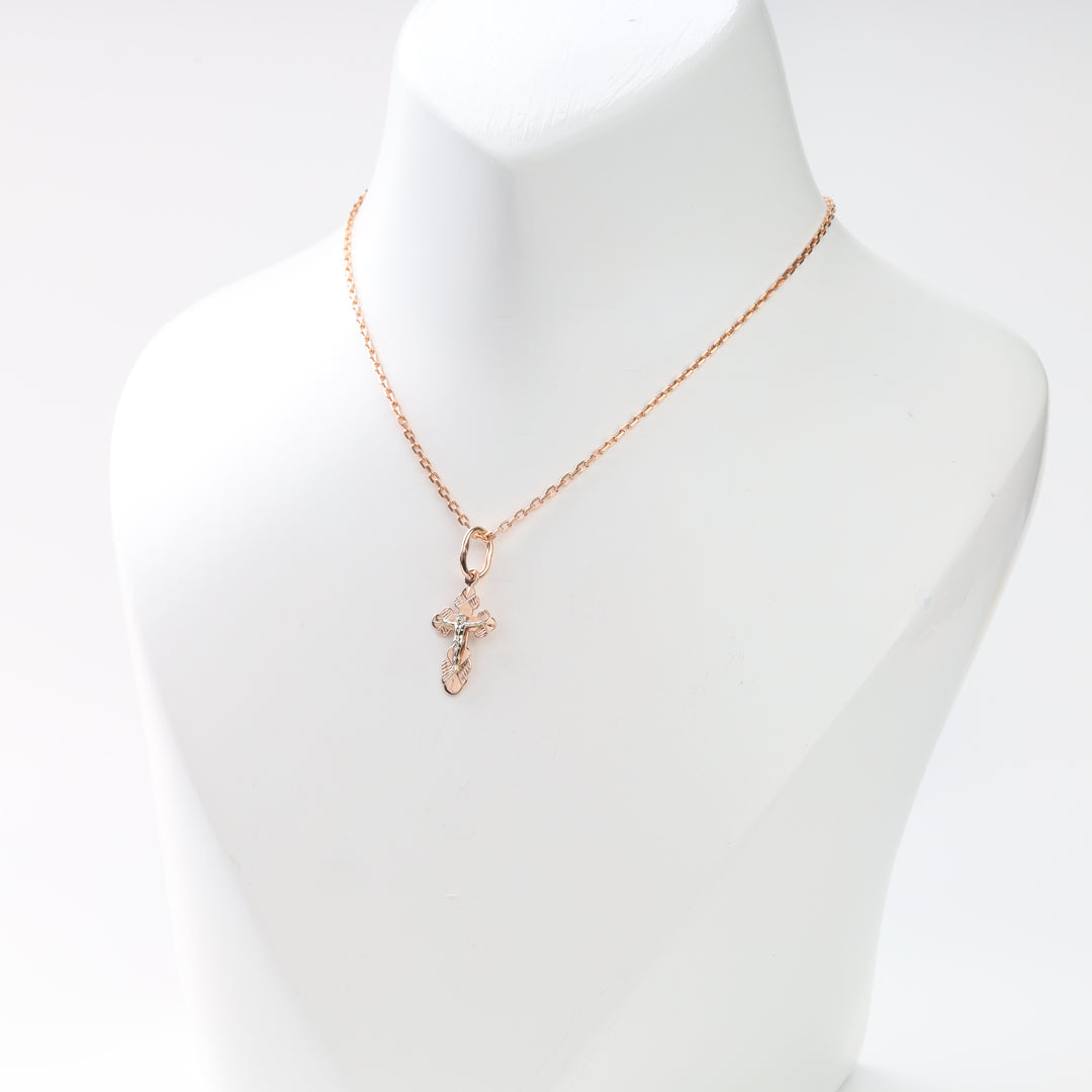 Back view of a two-tone crucifix cross pendant on a rose gold chain