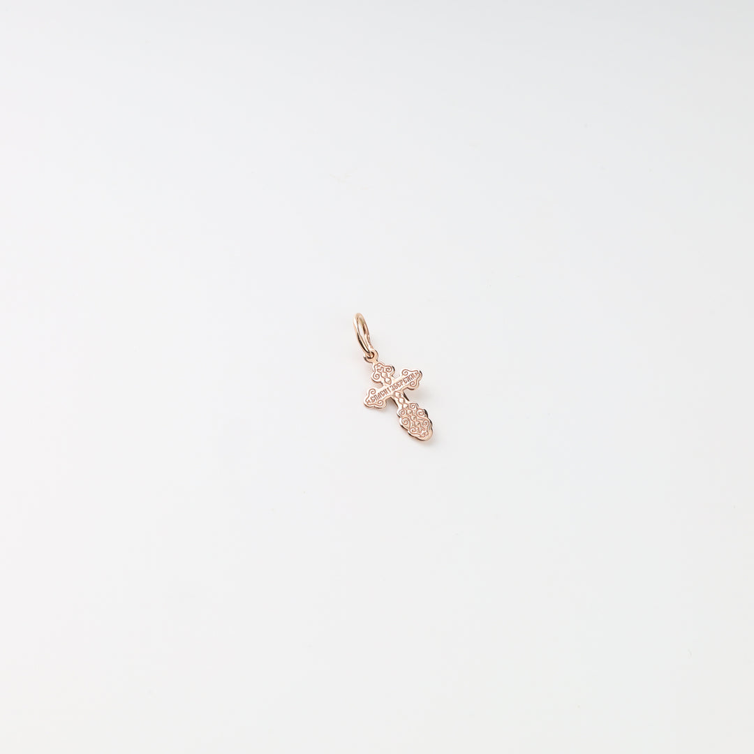 Front view of the small two-tone gold cross pendant on a white background