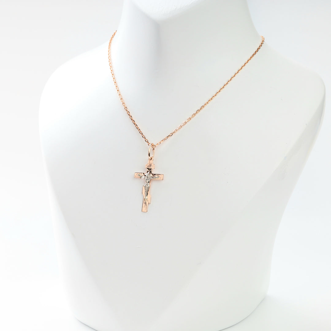 14K gold religious crucifix pendant shown on necklace display