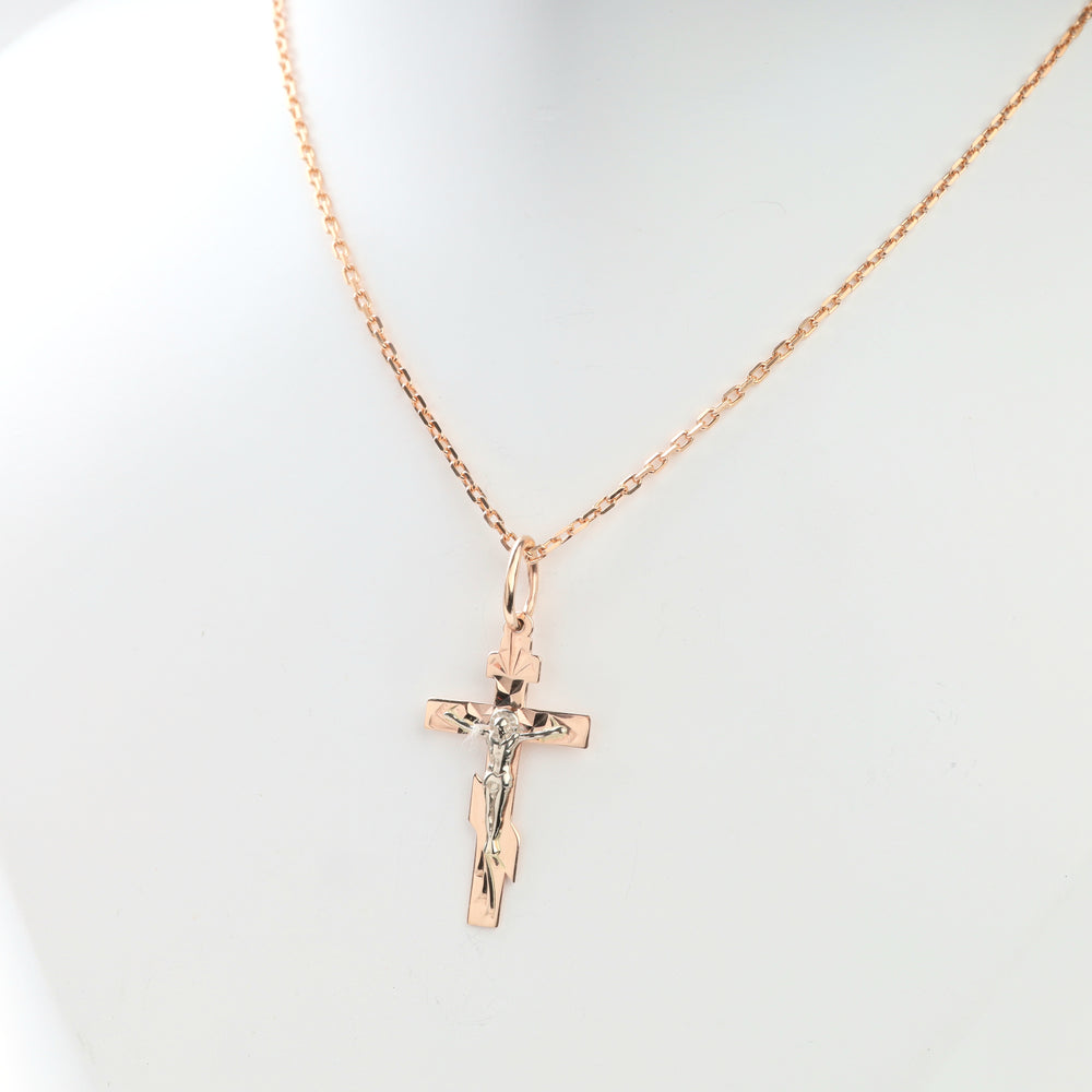 Close-up of faceted two-tone gold crucifix cross pendant