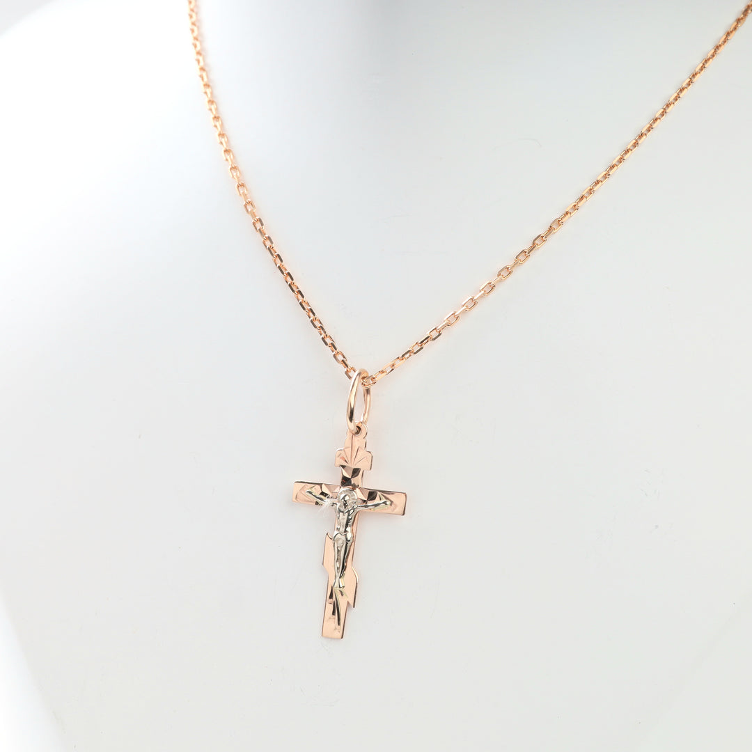 Close-up of faceted two-tone gold crucifix cross pendant