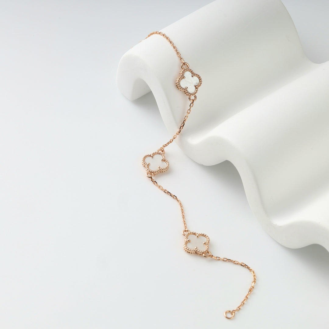 Close-up of a clover motif and the anchor chain of the rose gold bracelet