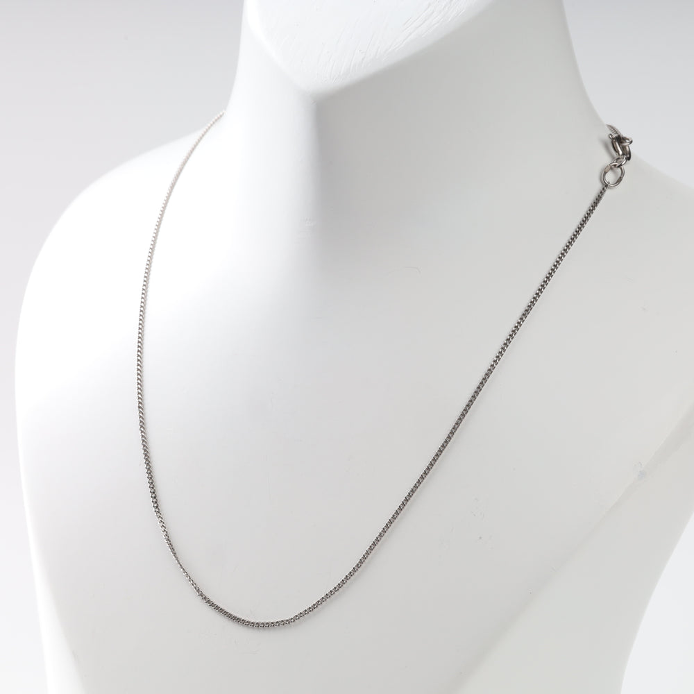 Side view of the white gold curb chain necklace with the lobster clasp at the shoulder