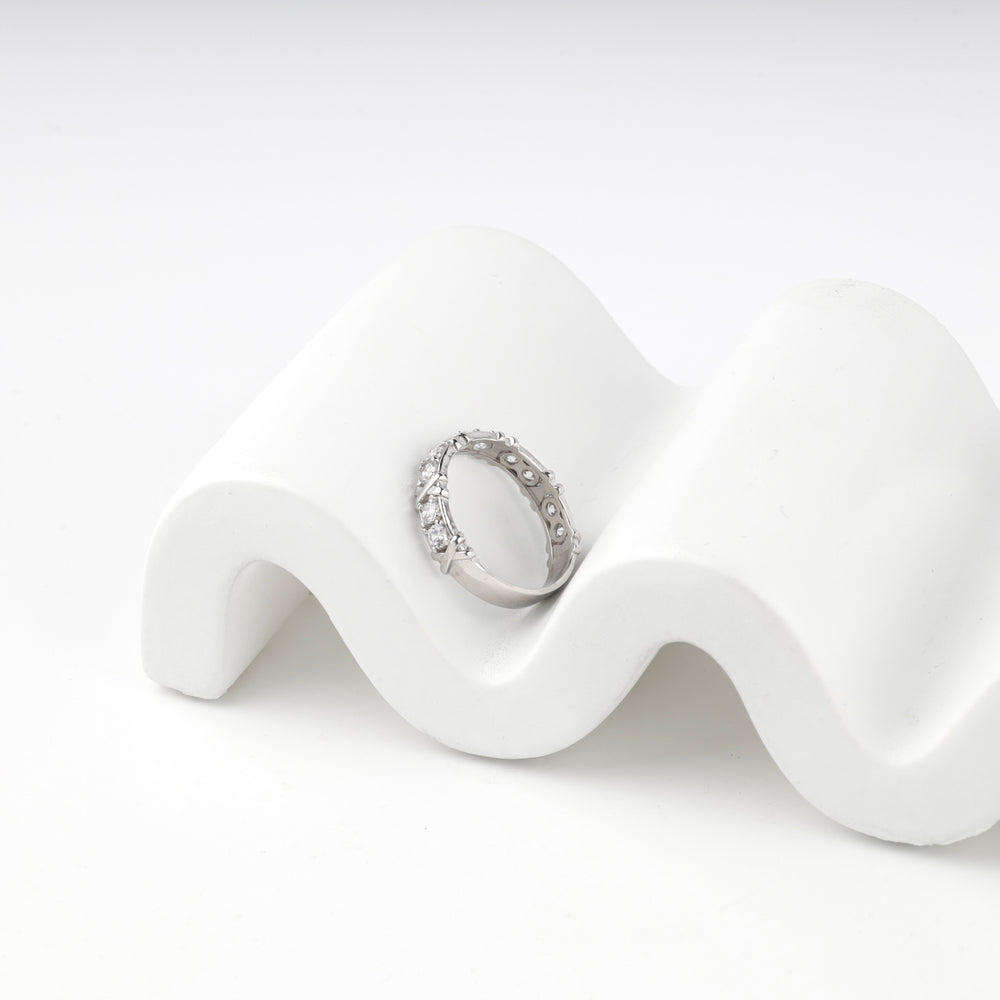 Silver 925 eternity ring standing on a wavy white prop