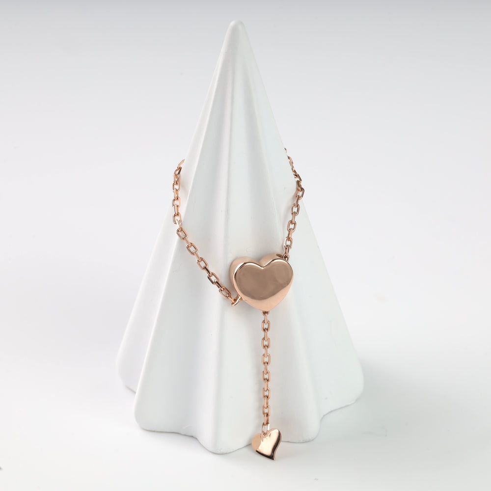 Rose gold chain ring with a polished heart centre on a white display cone