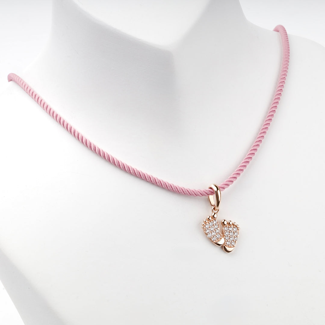 14K rose gold baby feet pendant with cubic zirconia, angled view