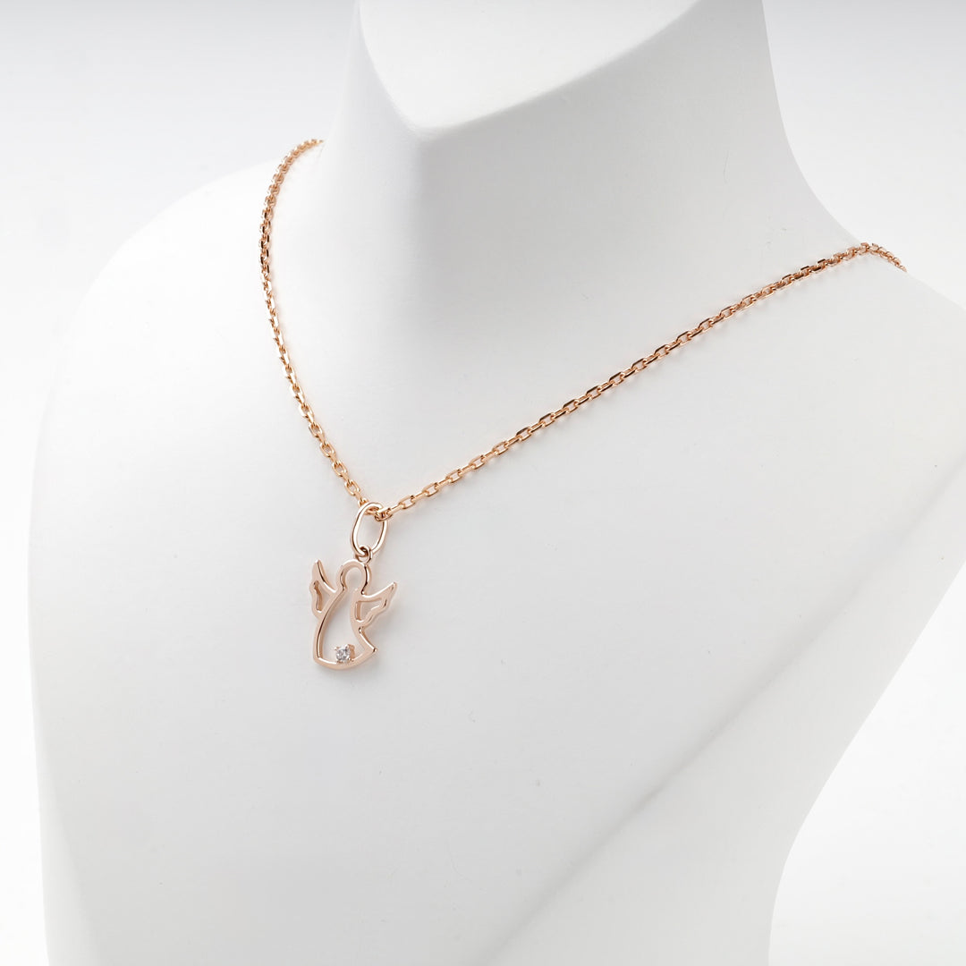 Rose gold angel pendant worn on a rose gold chain