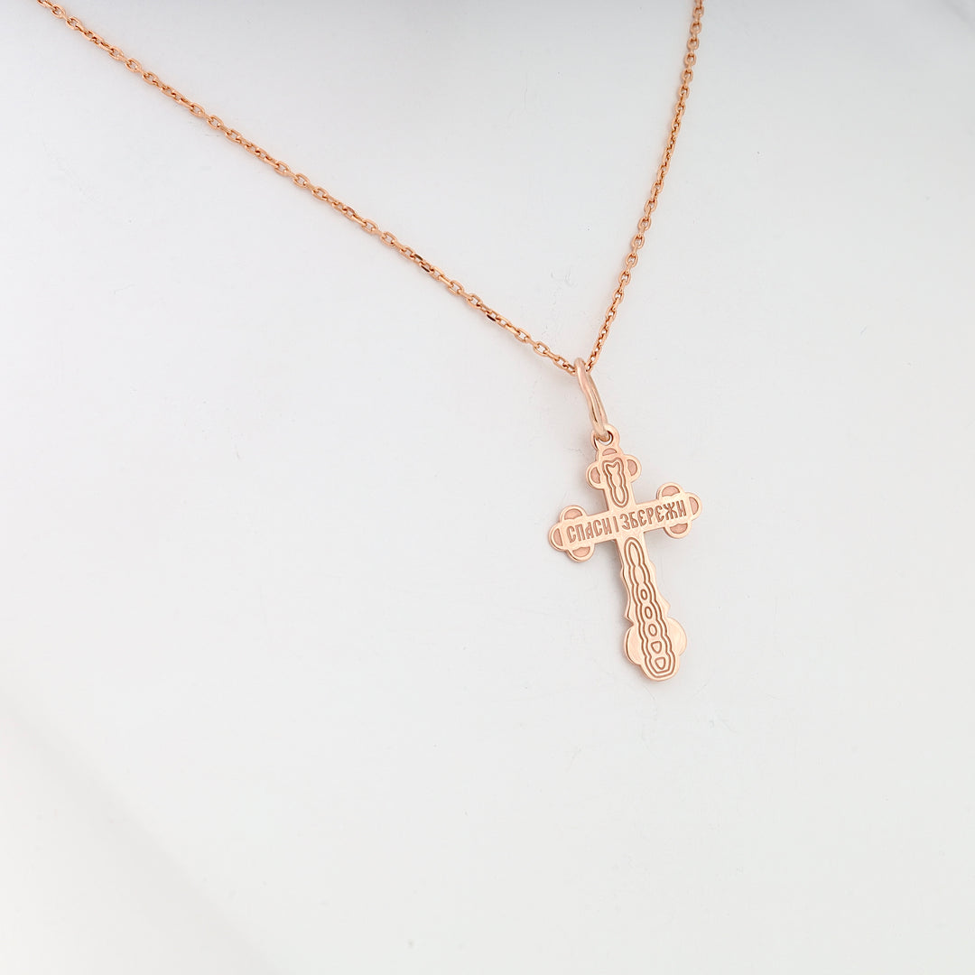 Rose gold Orthodox cross necklace with engraved text, featuring religious motif on a fine chain.