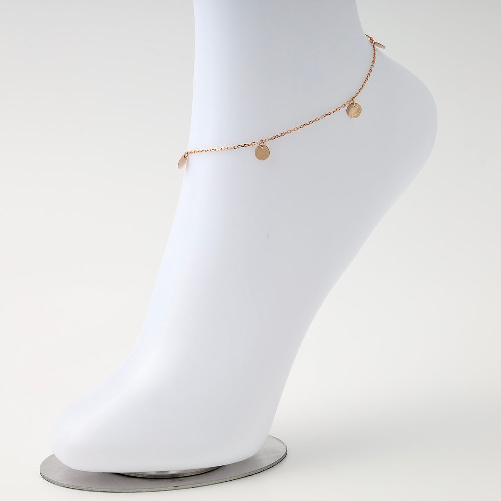 Delicate 14k gold anklet with small disc charms on chain, displayed on mannequin foot, minimalist Ukrainian Jewelry for women.