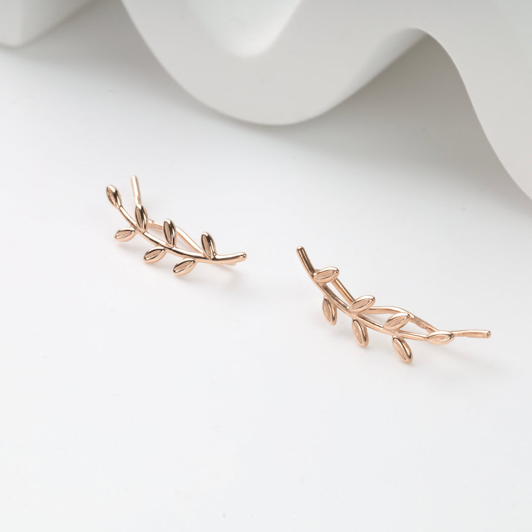 Pair of rose gold leaf branch ear climber earrings on white background, rose gold ear climbers, leaf branch earrings.