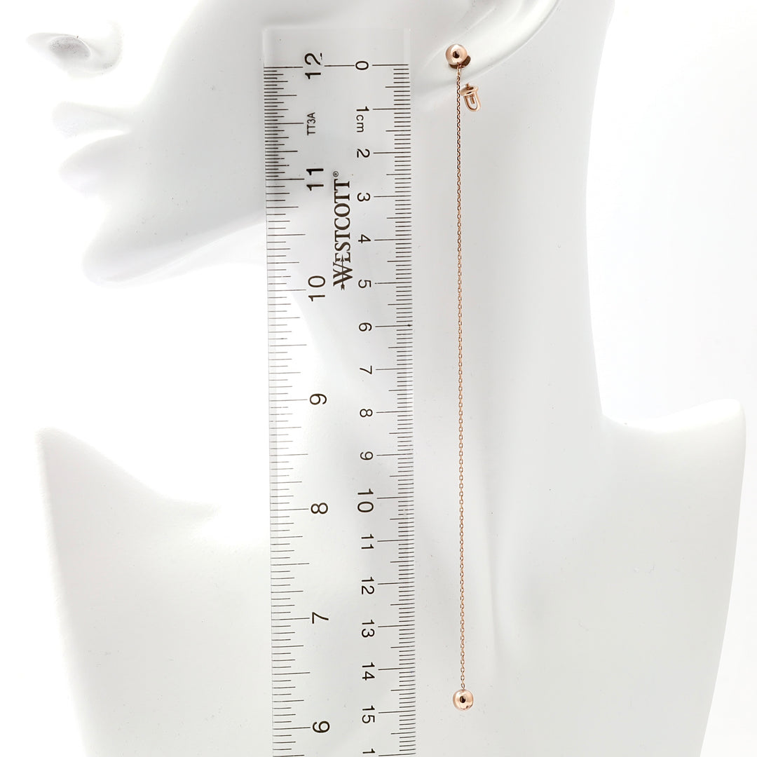 Single 14k gold threader drop earring with bead detail shown on ear beside ruler, minimalist Ukrainian Jewelry for women.