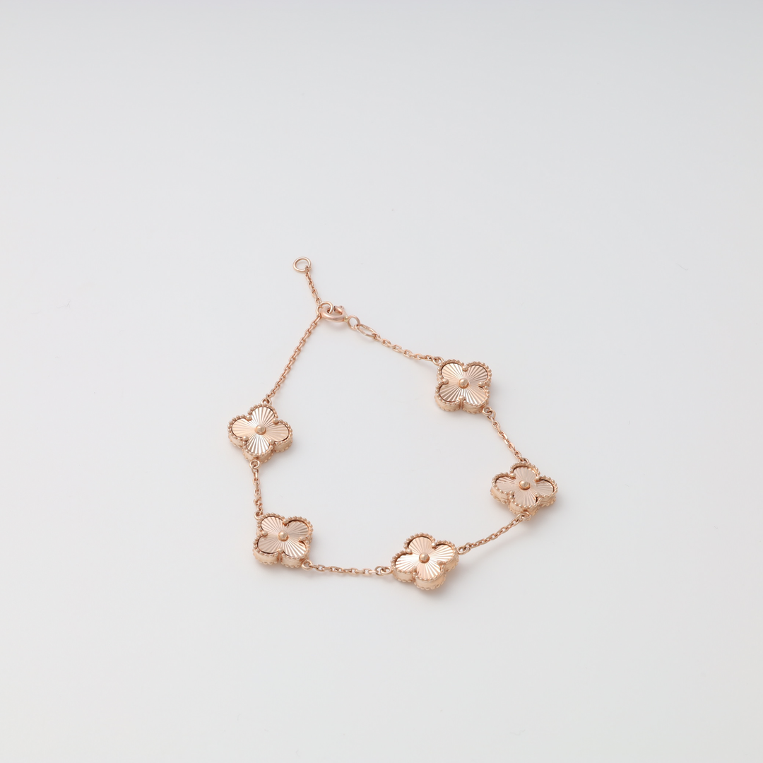 Rose gold bracelet with five flower-shaped charms on a chain, displayed on a white background.