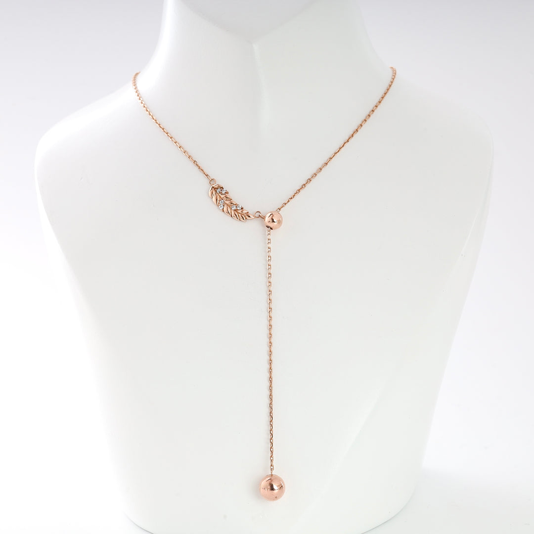 Rose gold lariat necklace with a leaf charm and adjustable chain displayed on a white bust.