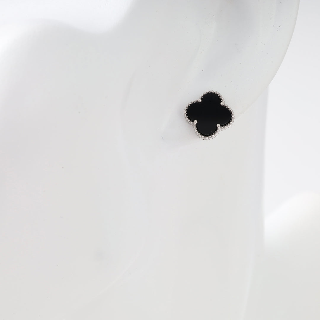 Sterling silver black clover stud earring on ear, minimalist Ukrainian Jewelry, small silver stud earrings.