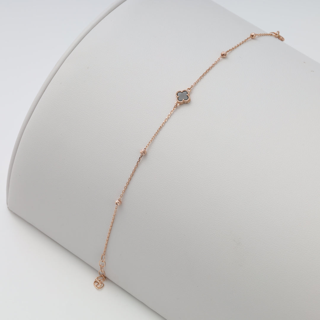 Delicate 14k rose gold bracelet with black clover charm and bead accents on display, Ukrainian Jewelry, dainty gold chain bracelet.