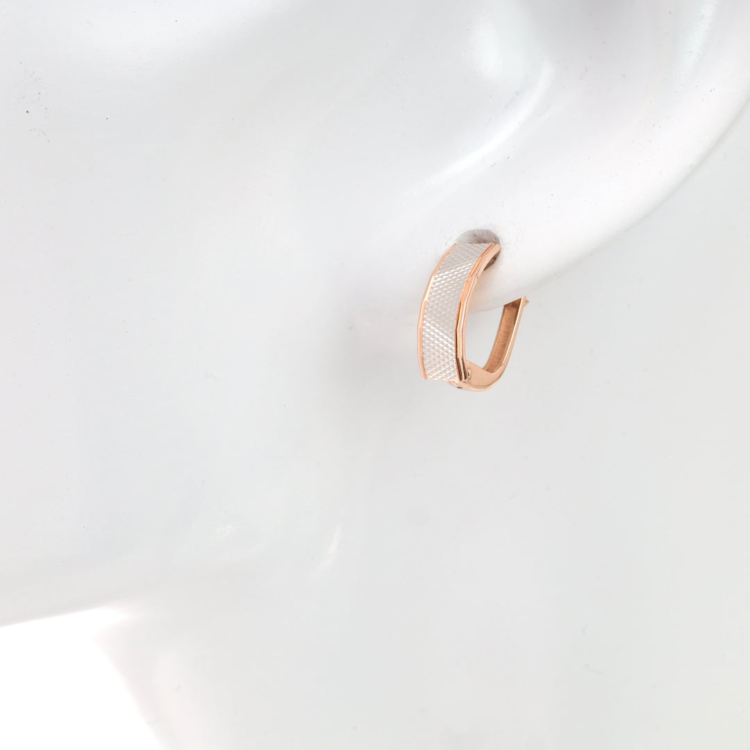 Rose gold and silver textured hoop earring displayed on mannequin.