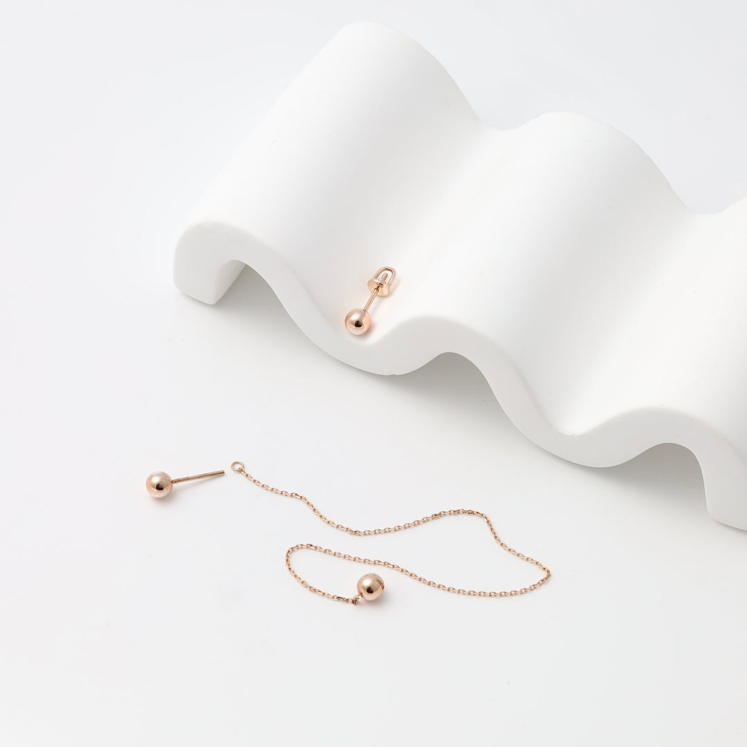 Rose gold plated sterling silver ball stud and chain drop earrings on white display, minimalist Ukrainian Jewelry for everyday wear.