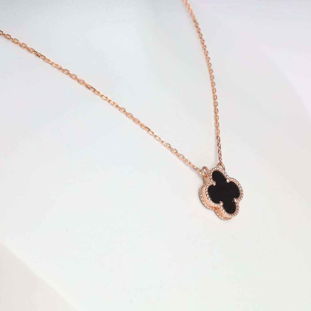 Rose gold chain necklace with a black clover pendant displayed on a white bust, jewelry, clover necklace.
