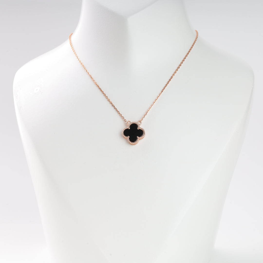 Gold chain necklace with a black clover pendant displayed on a white bust, suitable for jewelry, clover necklace, gold pendant.