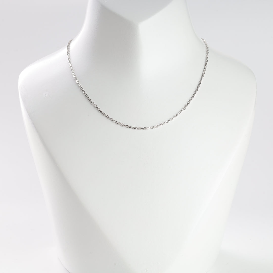 Thin silver chain necklace displayed on a white mannequin bust for jewelry, chain necklace, silver necklace searches.