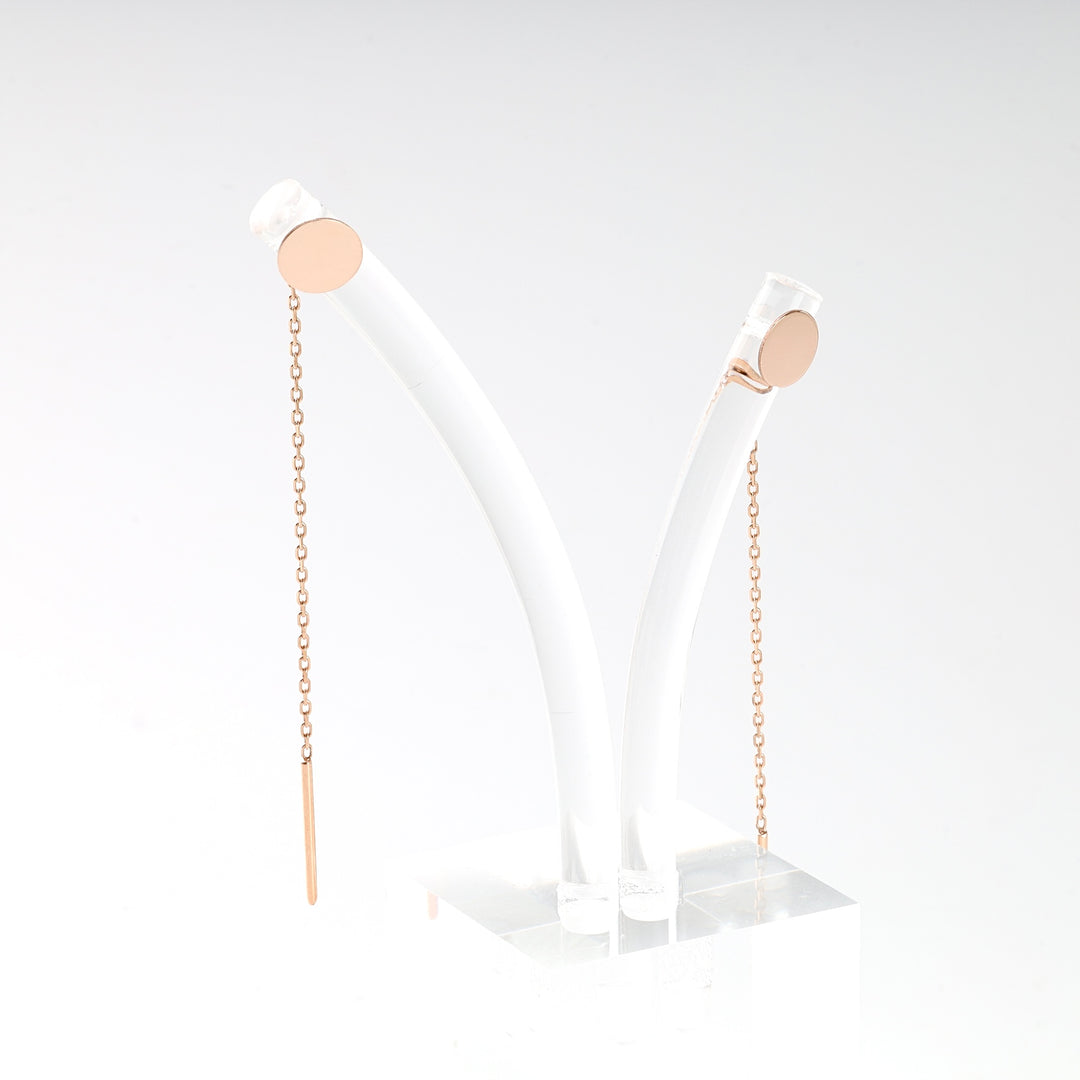Pair of rose gold threader earrings with circular studs and delicate chains, displayed on a white stand.