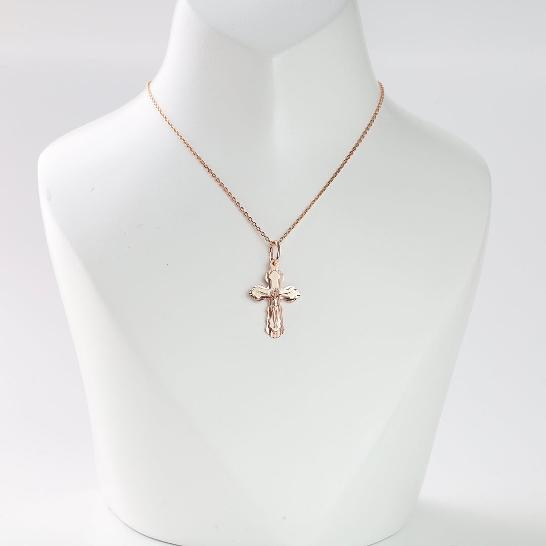 Gold crucifix pendant necklace displayed on a white bust, religious jewelry, cross charm, rose gold chain.