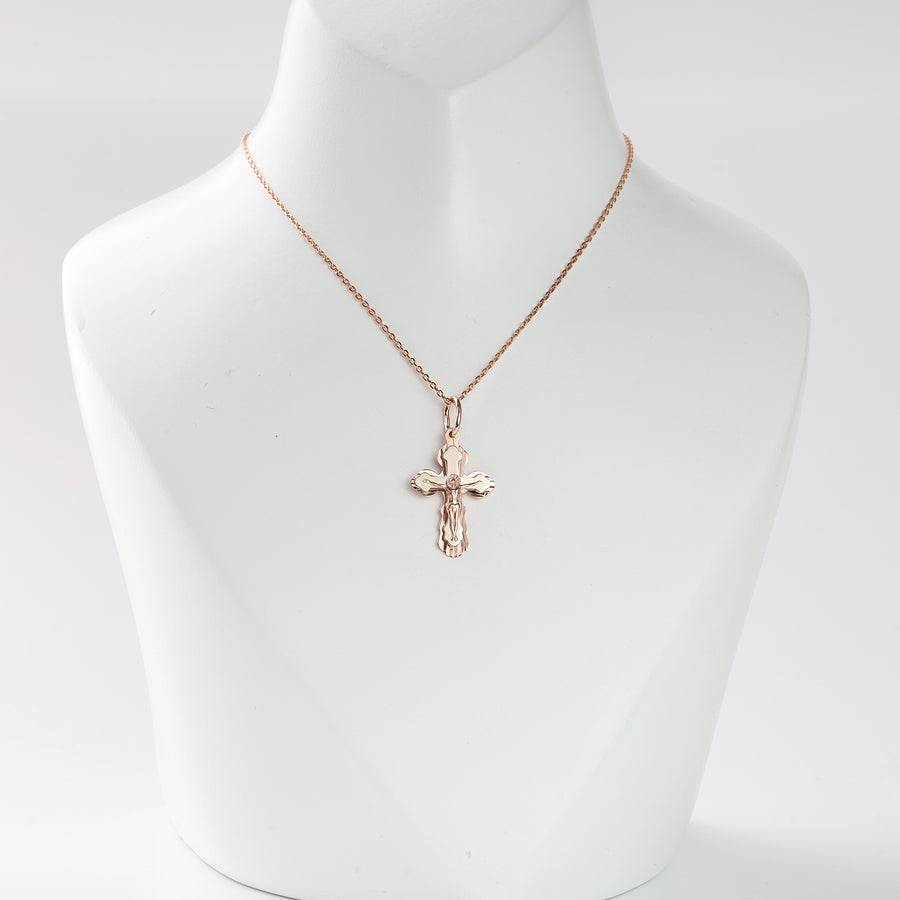 Gold crucifix pendant necklace displayed on a white bust, religious jewelry, cross charm, rose gold chain.