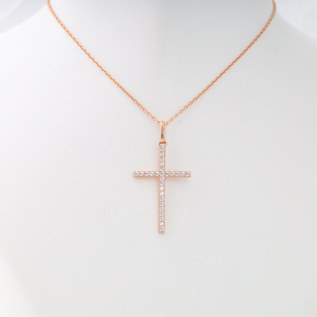 Rose gold chain necklace featuring a cross pendant set with clear crystals, displayed on a white mannequin bust.