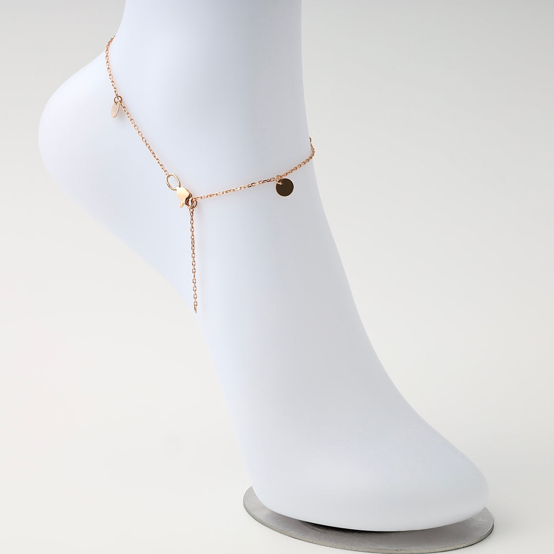 Delicate 14k gold anklet with small disc charms displayed on a white foot stand, Ukrainian Jewelry, minimalist gold ankle bracelet.