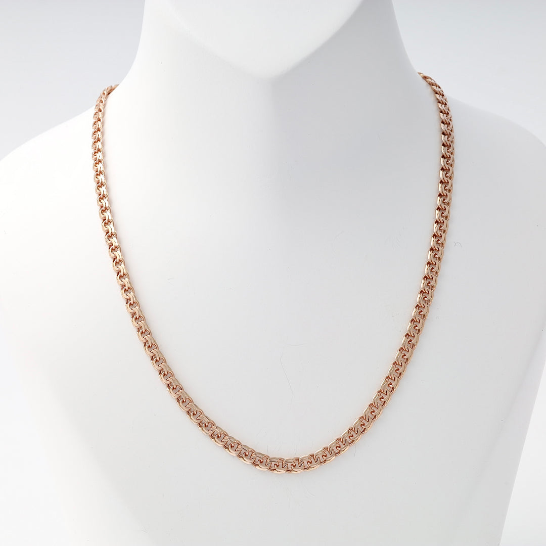 Rose gold chain necklace with intricate Byzantine links displayed on a white bust statue.