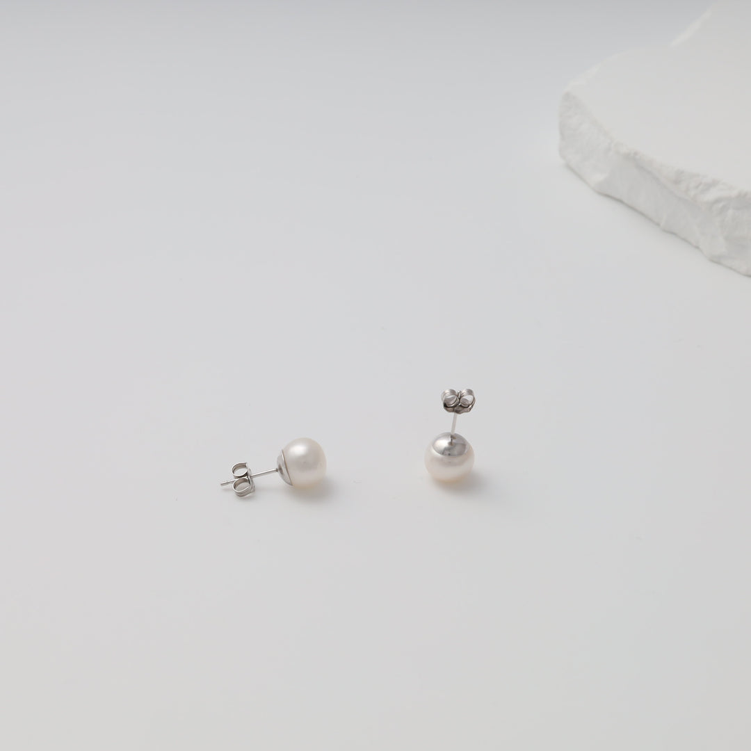 Sterling silver pearl stud earrings on a white background, classic round design, Ukrainian Jewelry, perfect bridal earrings.
