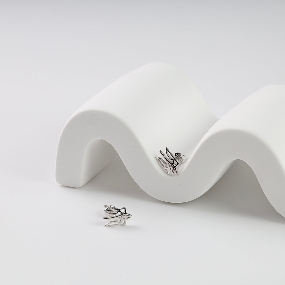 Pair of silver bird-shaped stud earrings displayed on a white wavy stand, minimalist jewelry.