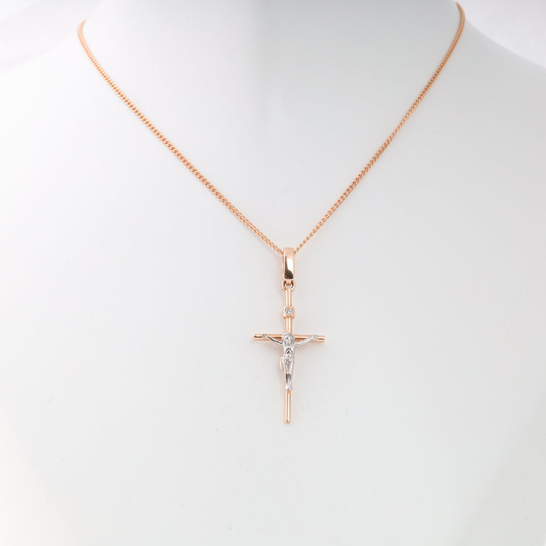 Gold chain necklace with a two-tone crucifix cross pendant displayed on a white mannequin.