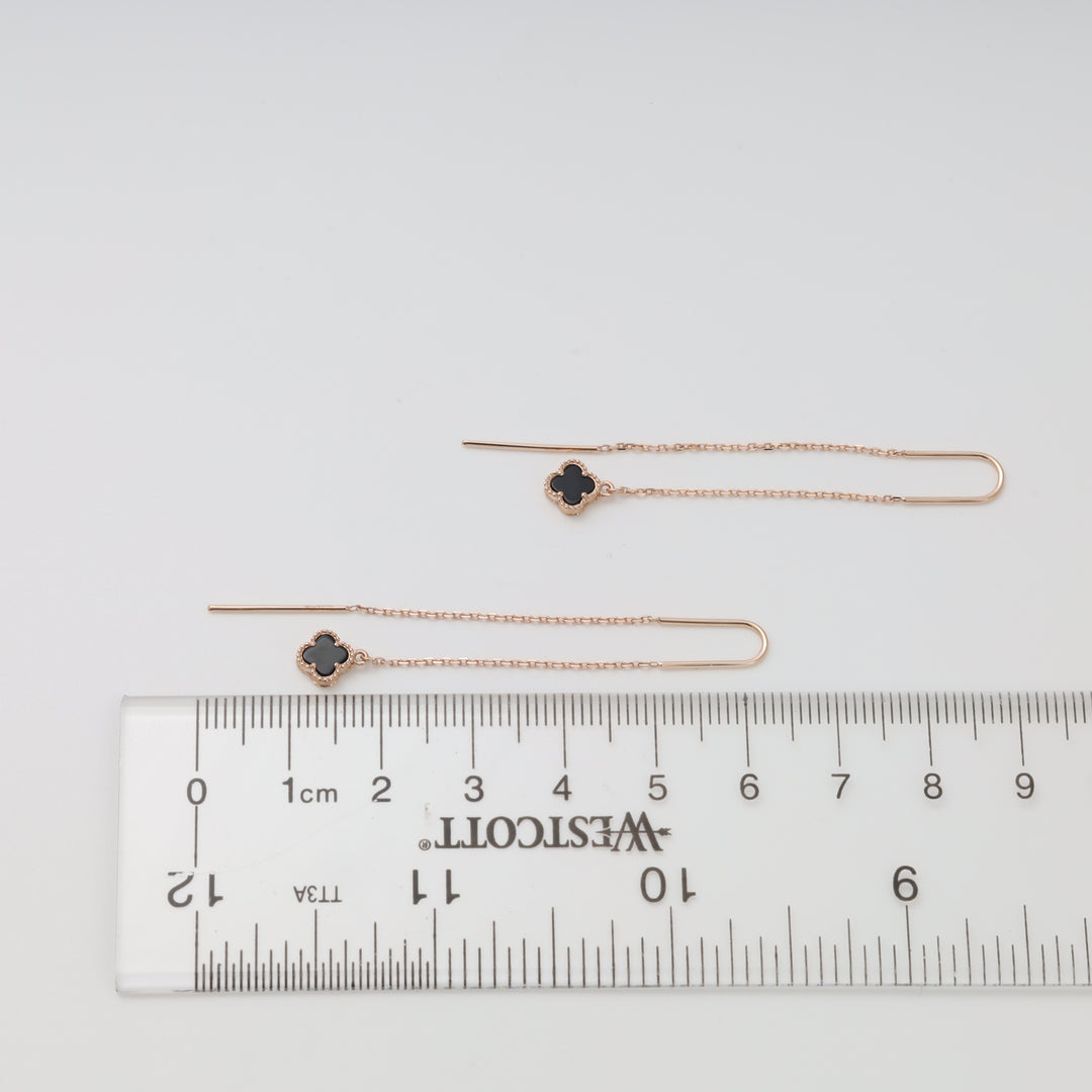 14k gold threader earrings with black clover charms on chain, displayed by ruler, Ukrainian Jewelry, dainty gold drop earrings.